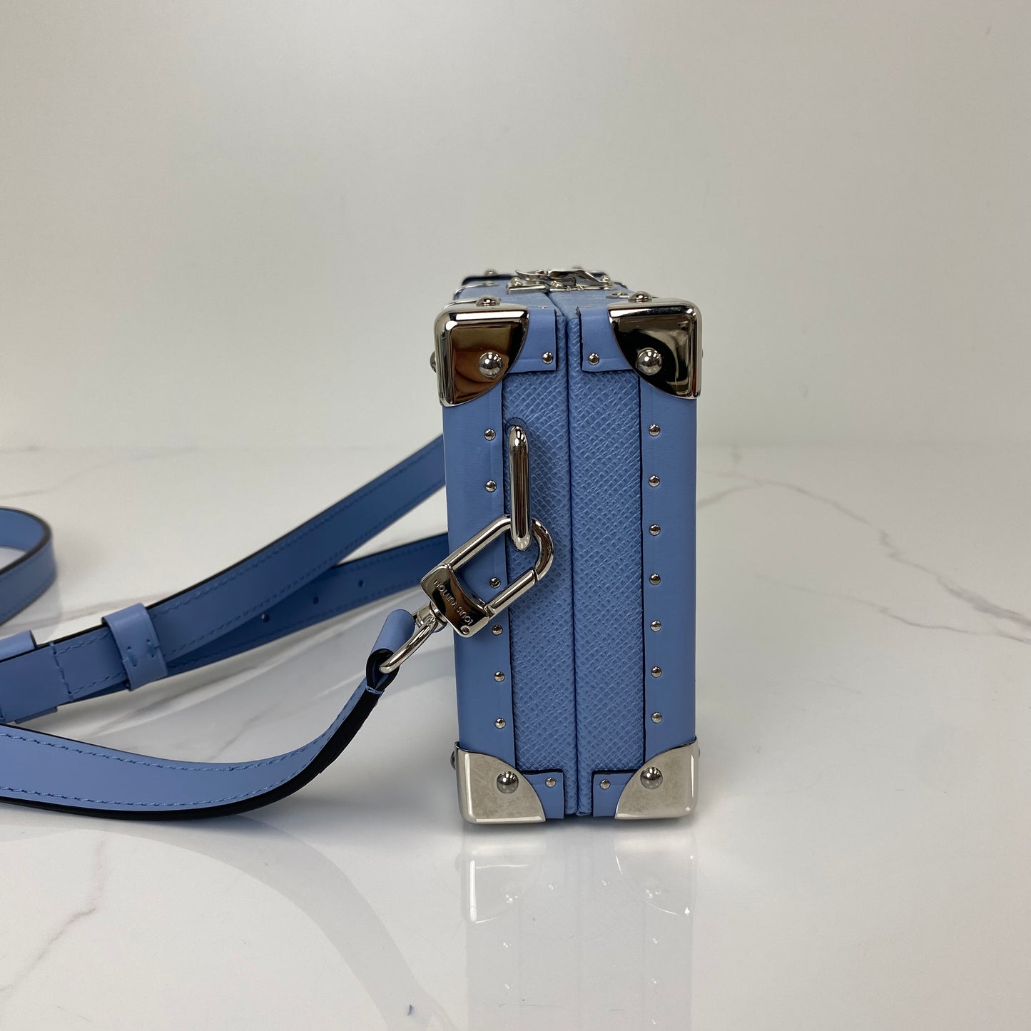 Side profile of the Louis Vuitton Wallet Trunk with adjustable leather strap