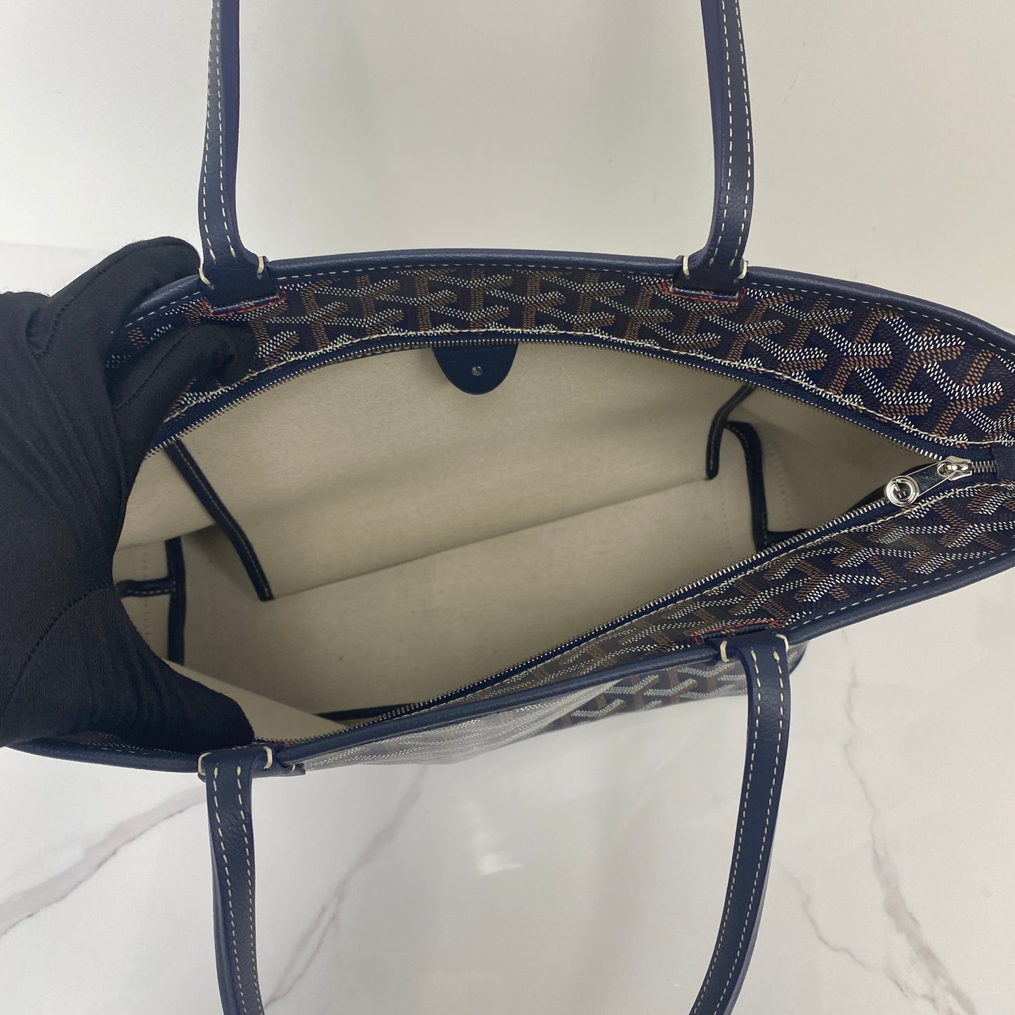 Interior of the Goyard Artois PM showing the lined compartment and zip pocket