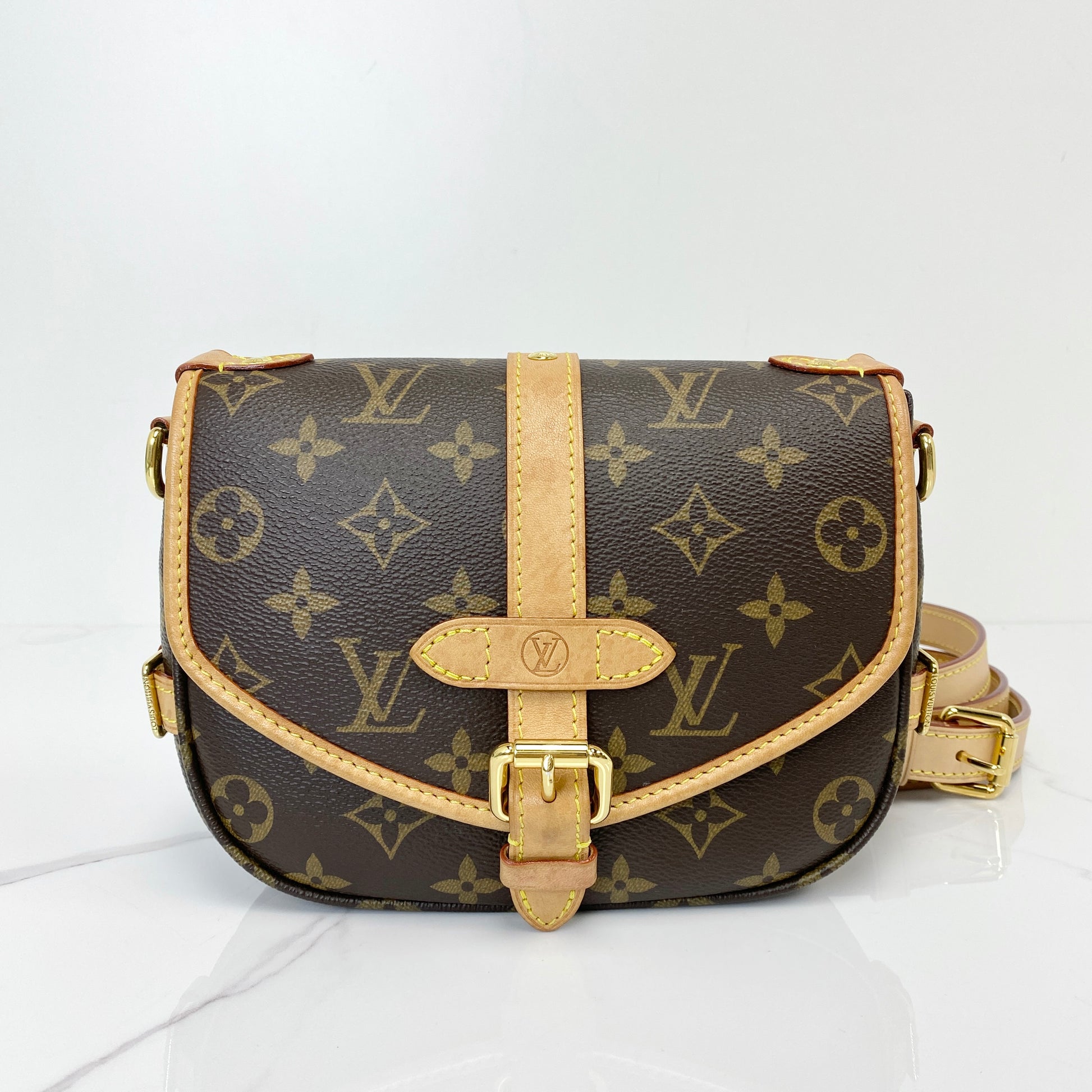 Louis Vuitton Saumur BB saddle bag in Monogram coated canvas with vachetta buckle strap