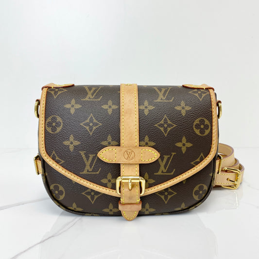 Louis Vuitton Saumur BB saddle bag in Monogram coated canvas with vachetta buckle strap