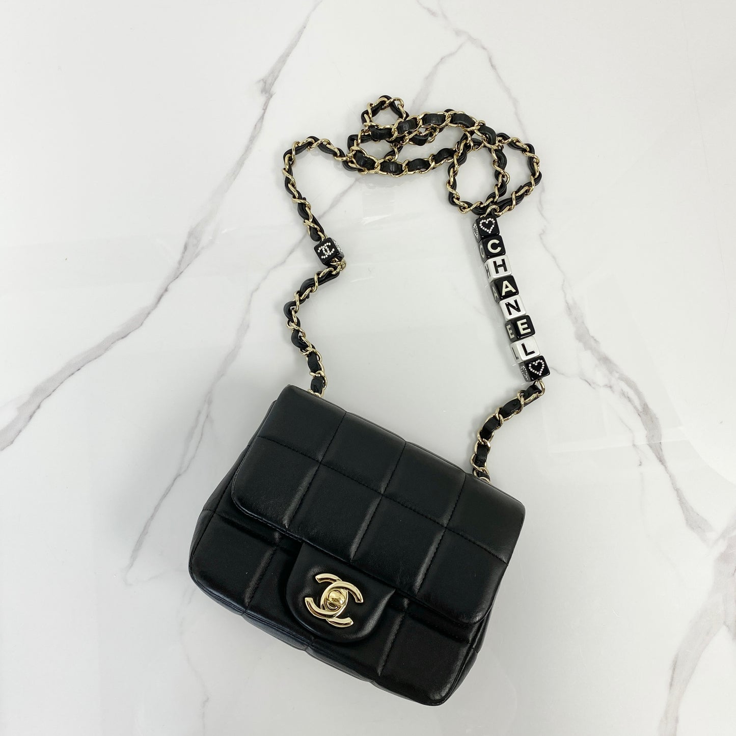 Chanel 23C mini flap bag in black lambskin with lettered CHANEL chain strap