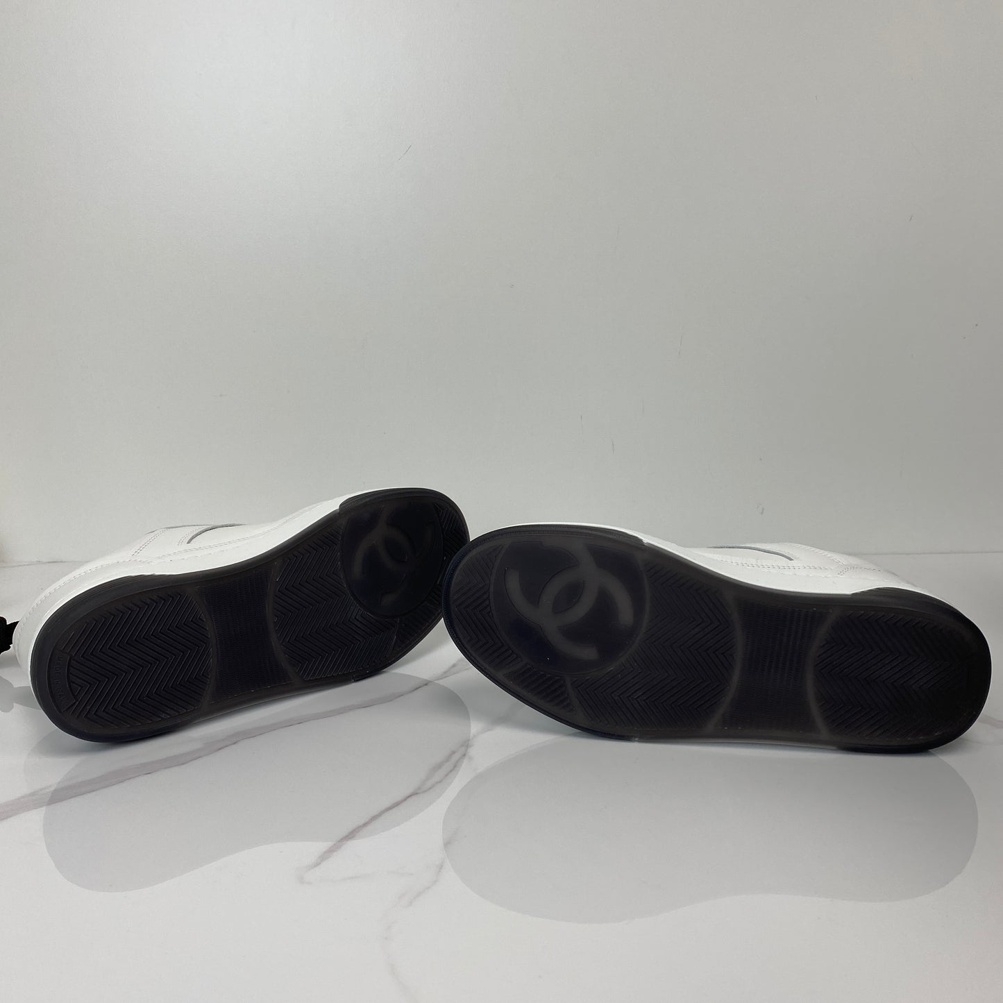 Chanel sneakers shown with their box and dustbag