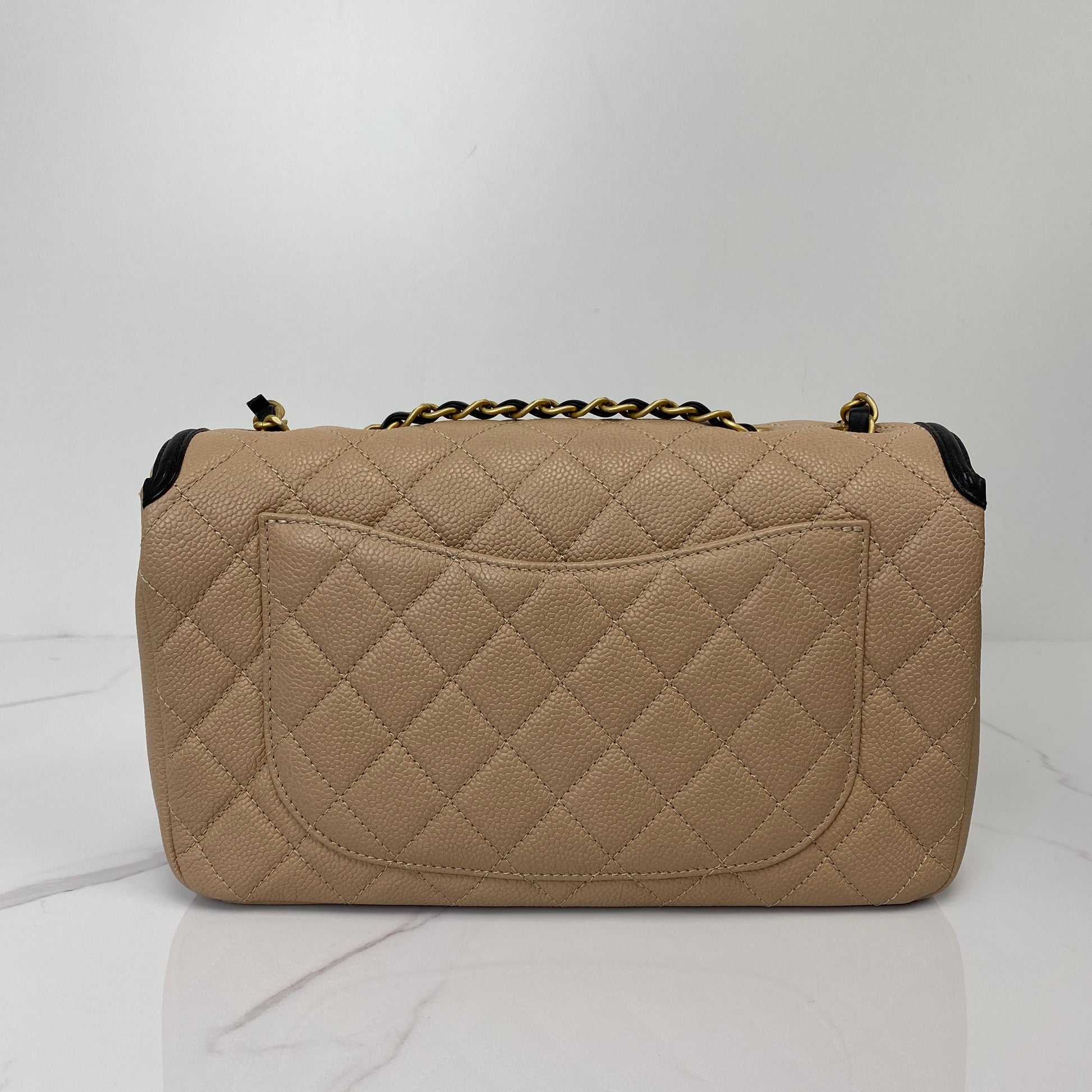 Side profile of the beige and black Chanel Filigree flap