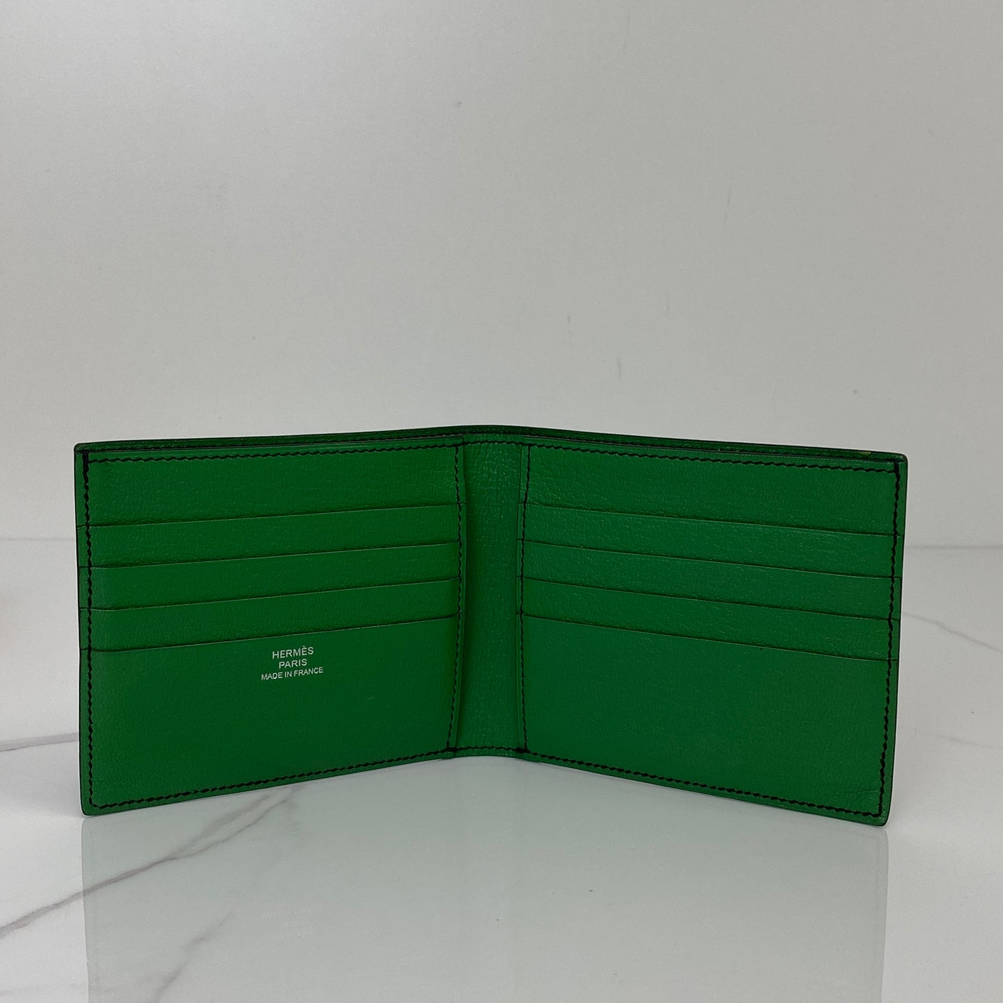 Open interior of the Hermès MC2 Copernic wallet with green card slots