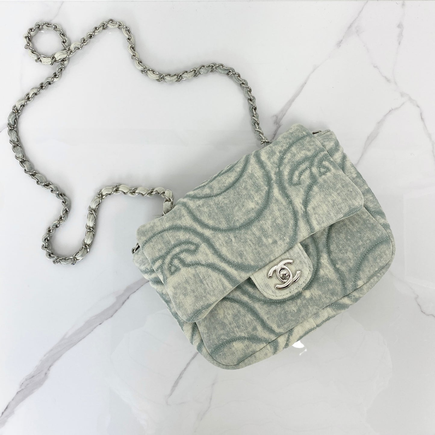 Chanel denim flap bag in washed blue with printed CC motif and silver chain strap