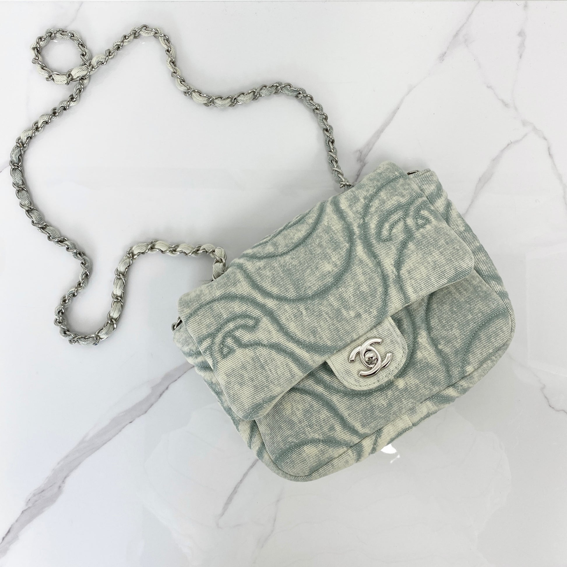 Chanel denim flap bag in washed blue with printed CC motif and silver chain strap
