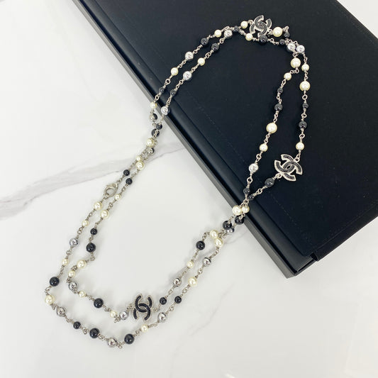Chanel Classic CC crystal and faux pearl double strand long necklace with silver-tone CC charms, laid flat