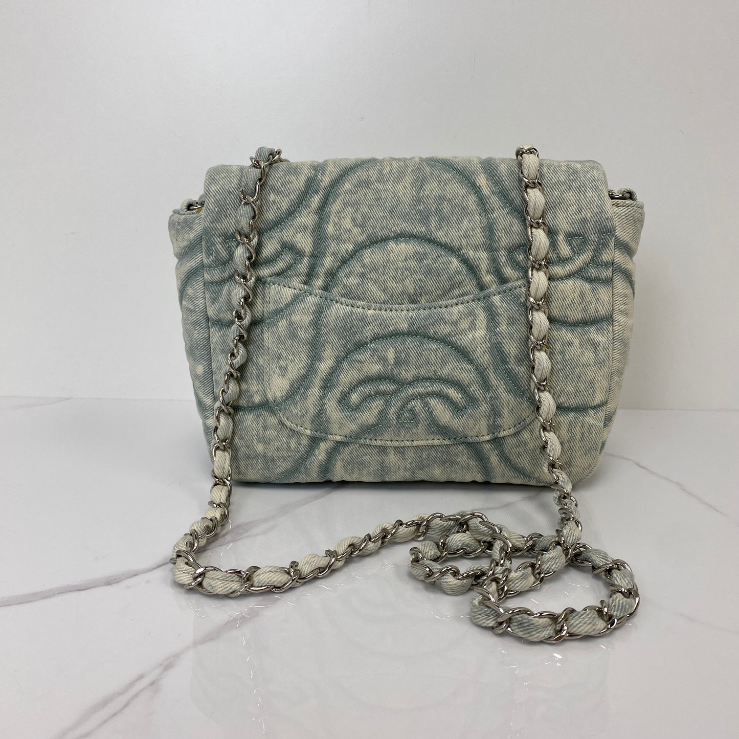 Front view of the Chanel denim flap bag with its leather-woven silver chain