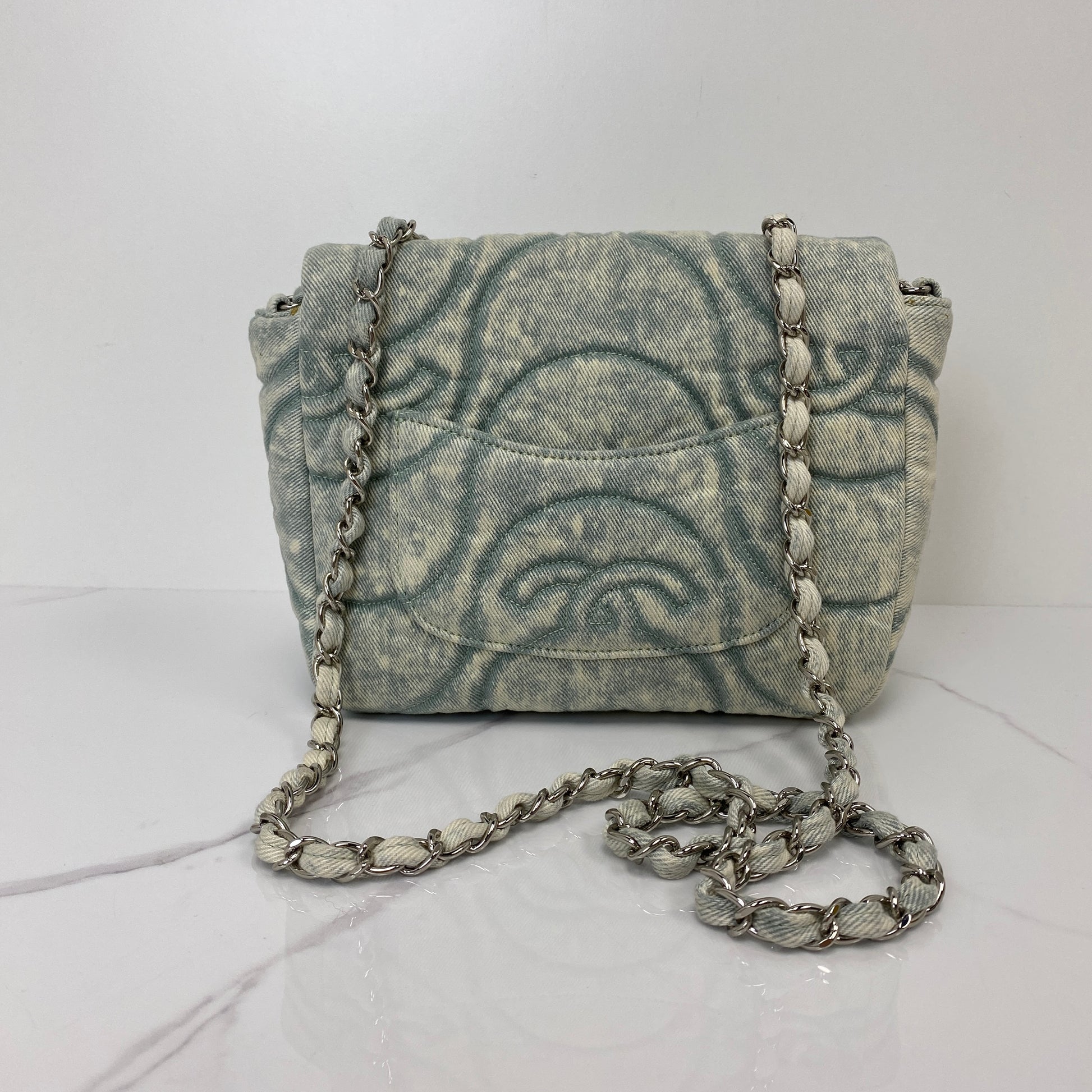 Front view of the Chanel denim flap bag with its leather-woven silver chain