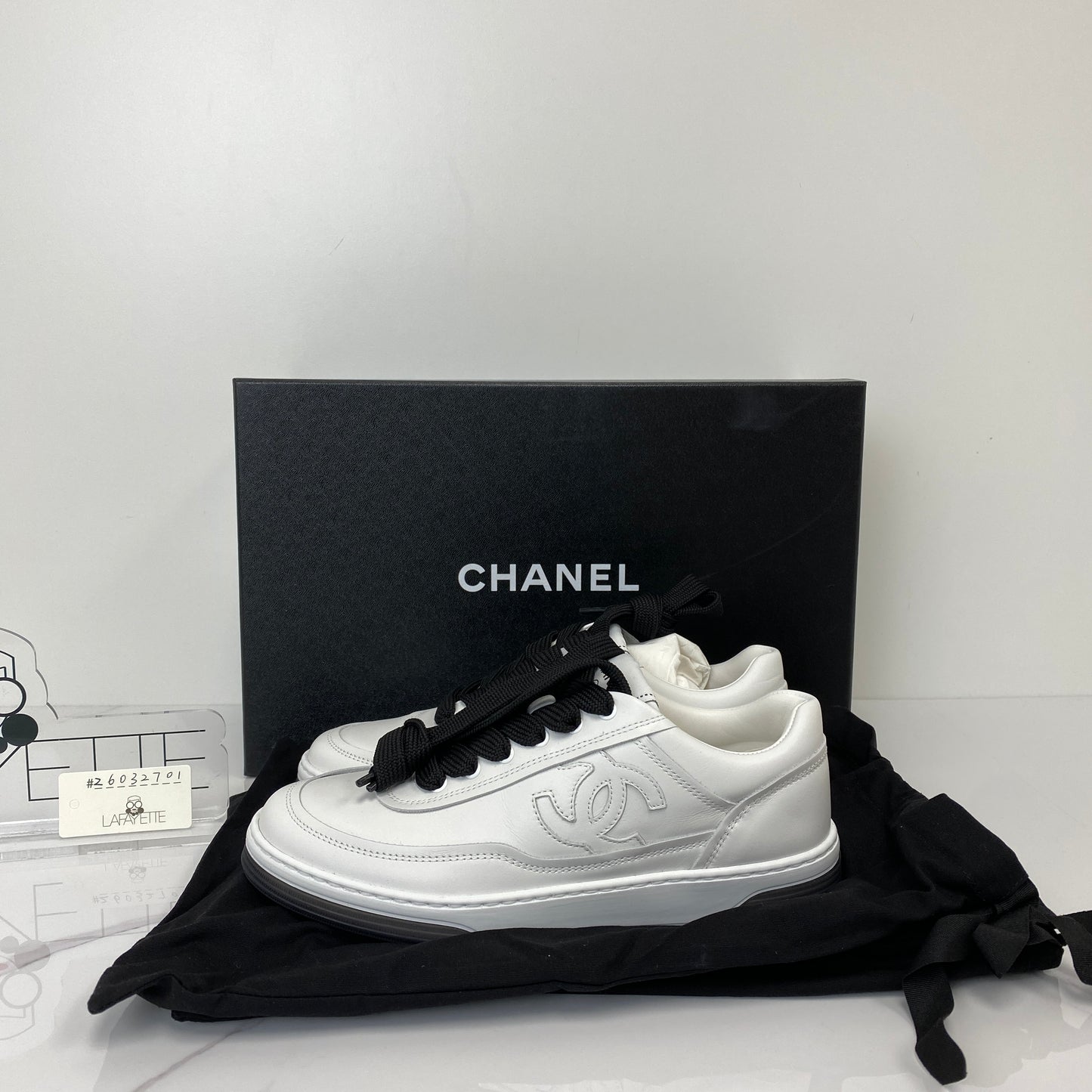 Side profile of the Chanel white and black sneakers