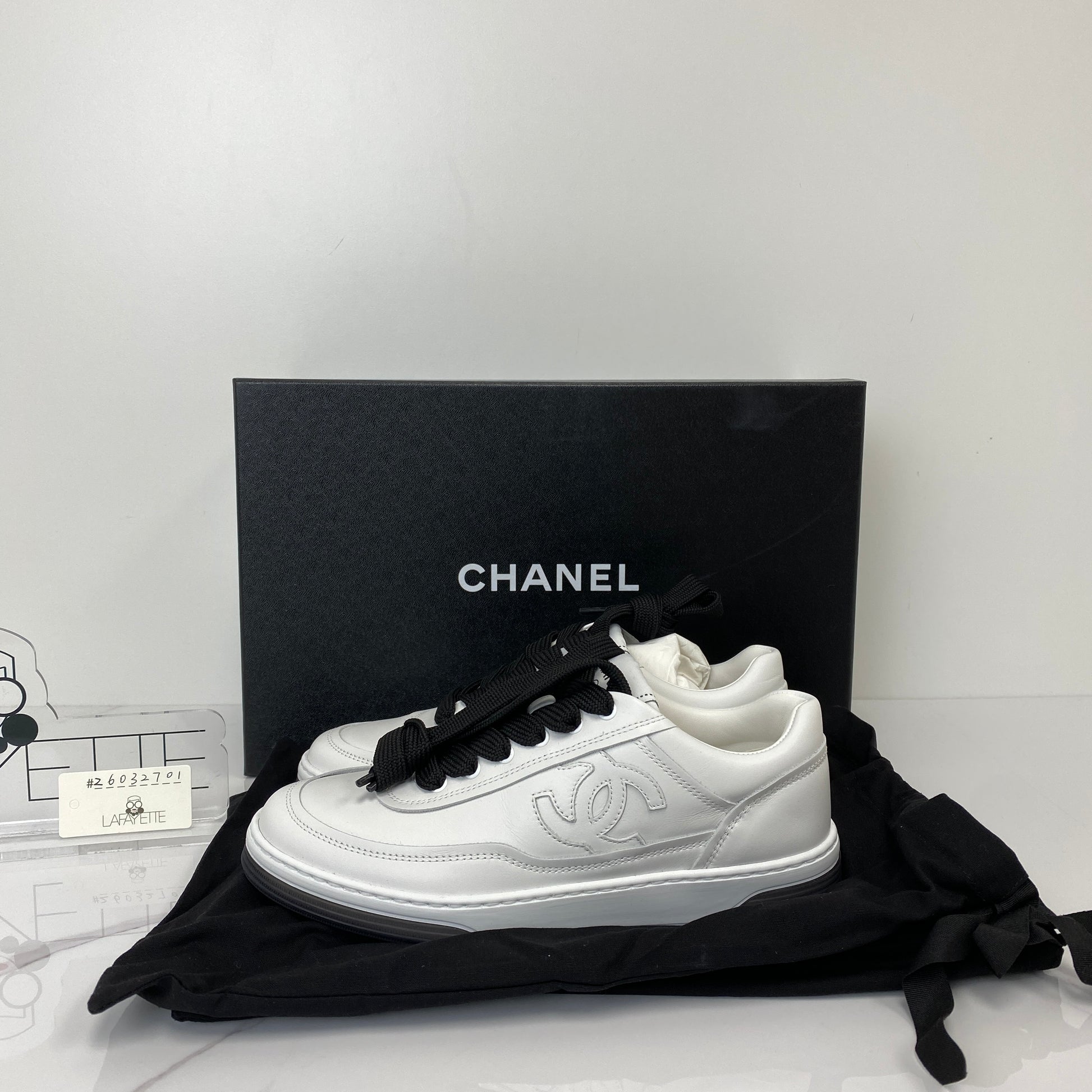 Side profile of the Chanel white and black sneakers