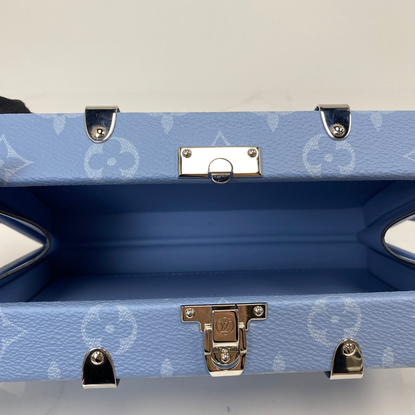 Open interior of the Louis Vuitton Wallet Trunk showing the blue lining and S-lock