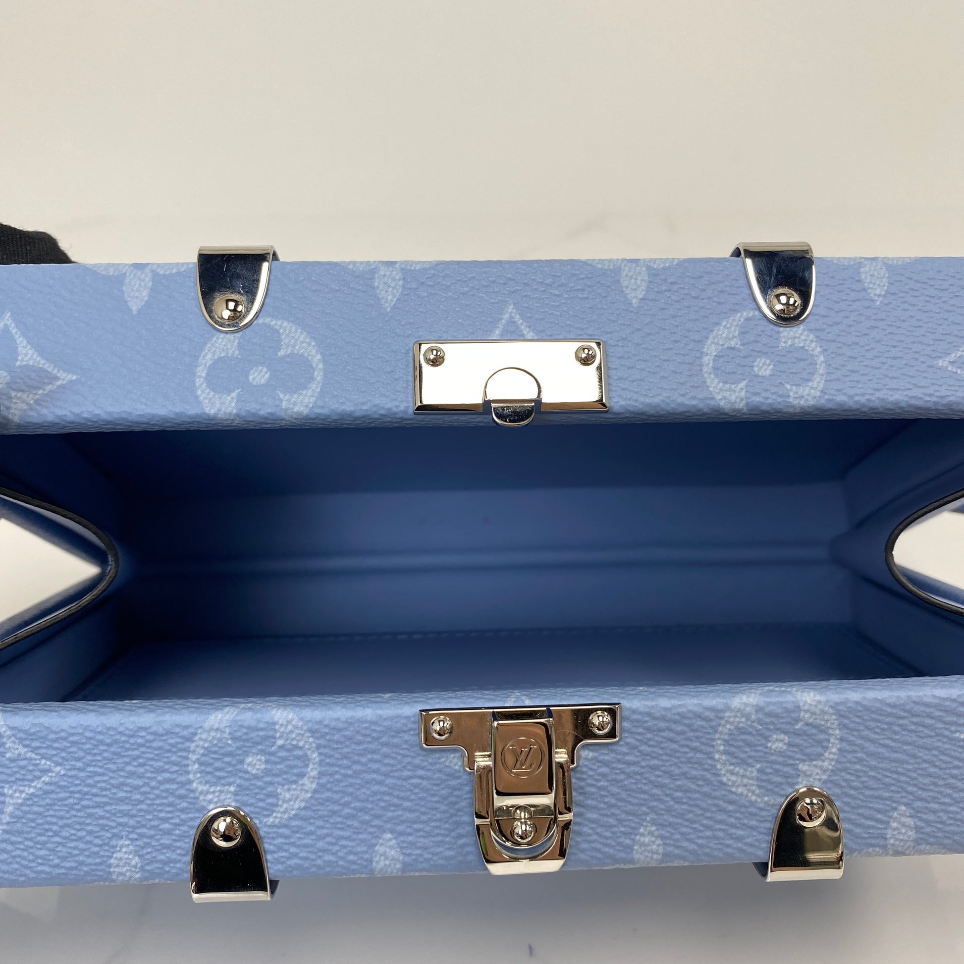 Open interior of the Louis Vuitton Wallet Trunk showing the blue lining and S-lock