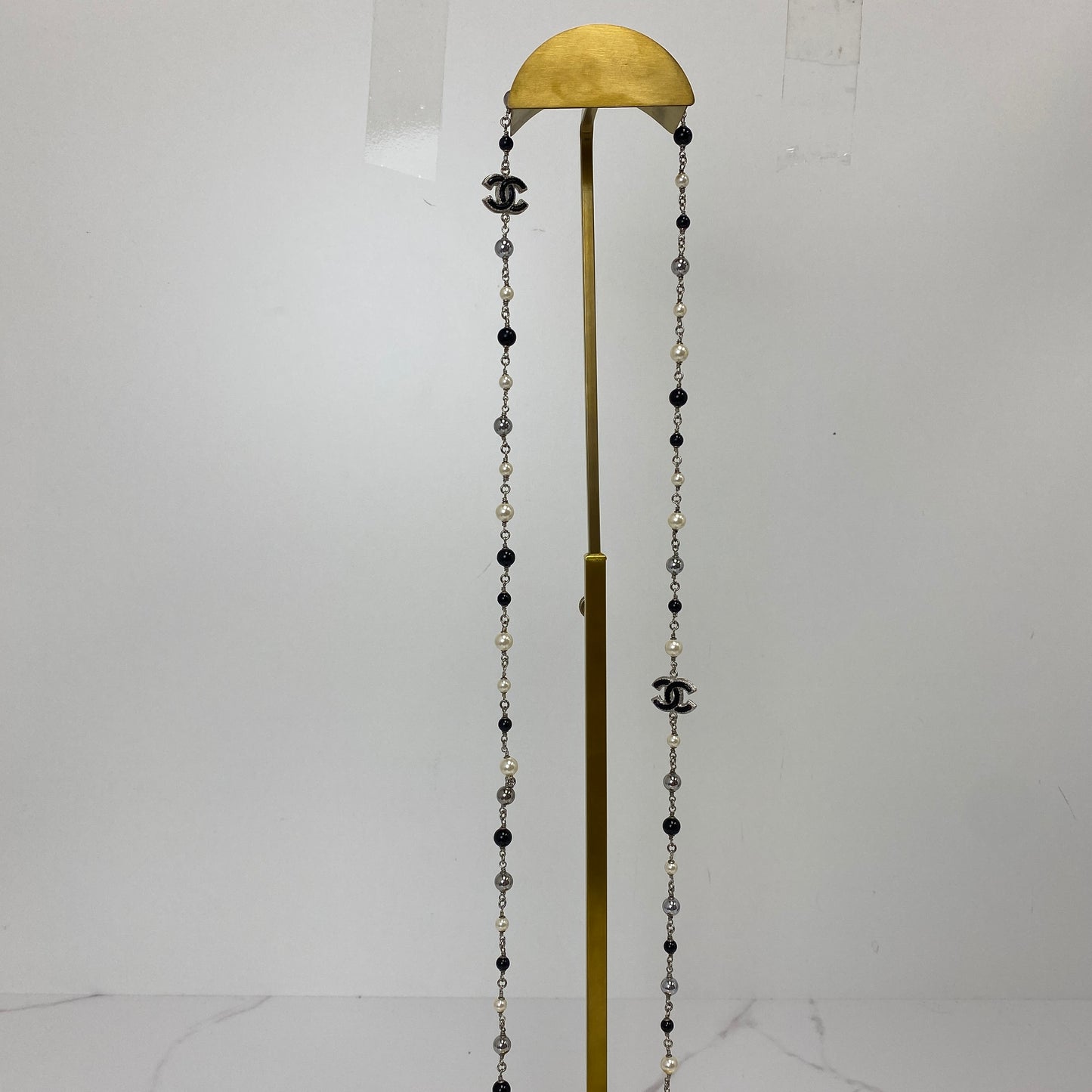 Full length view of the Chanel 160cm double strand pearl and crystal bead necklace on a display stand