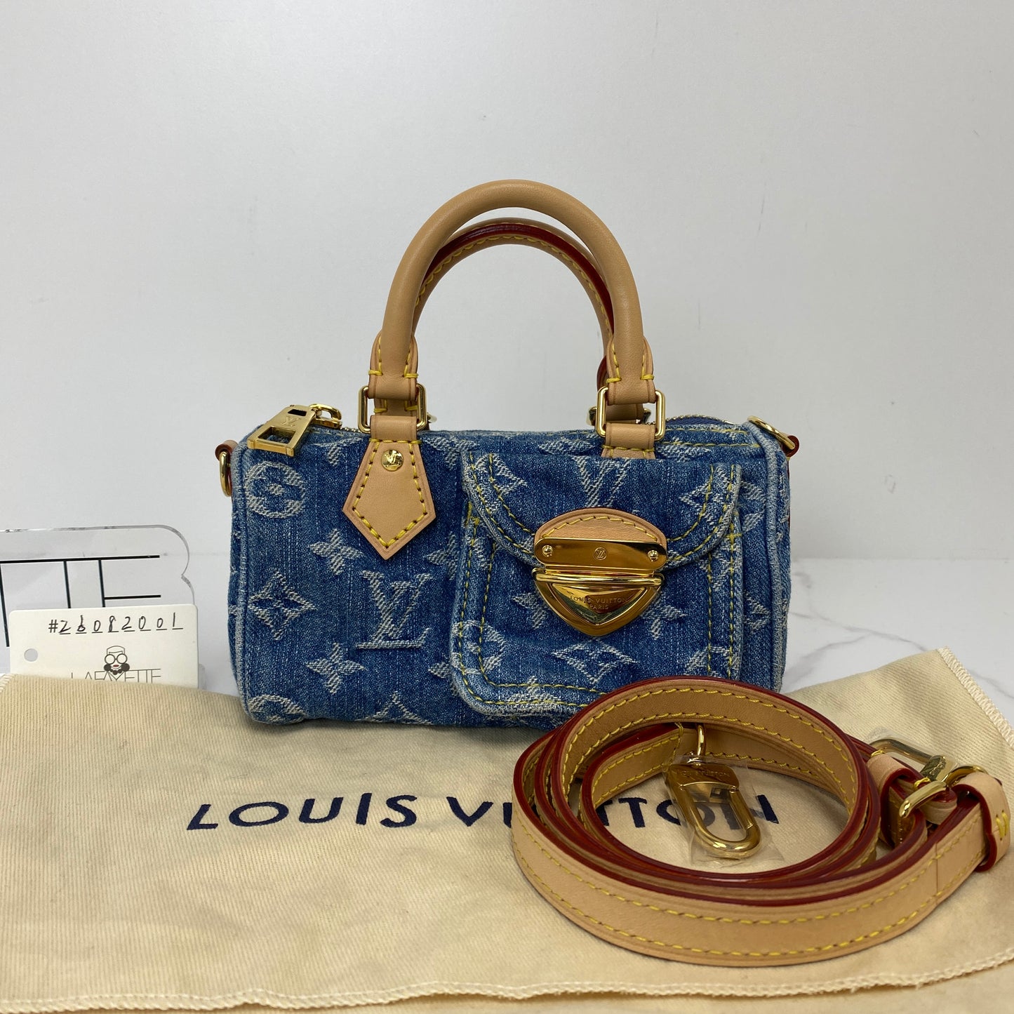 Louis Vuitton Nano Speedy shown with its included dustbag and adjustable strap