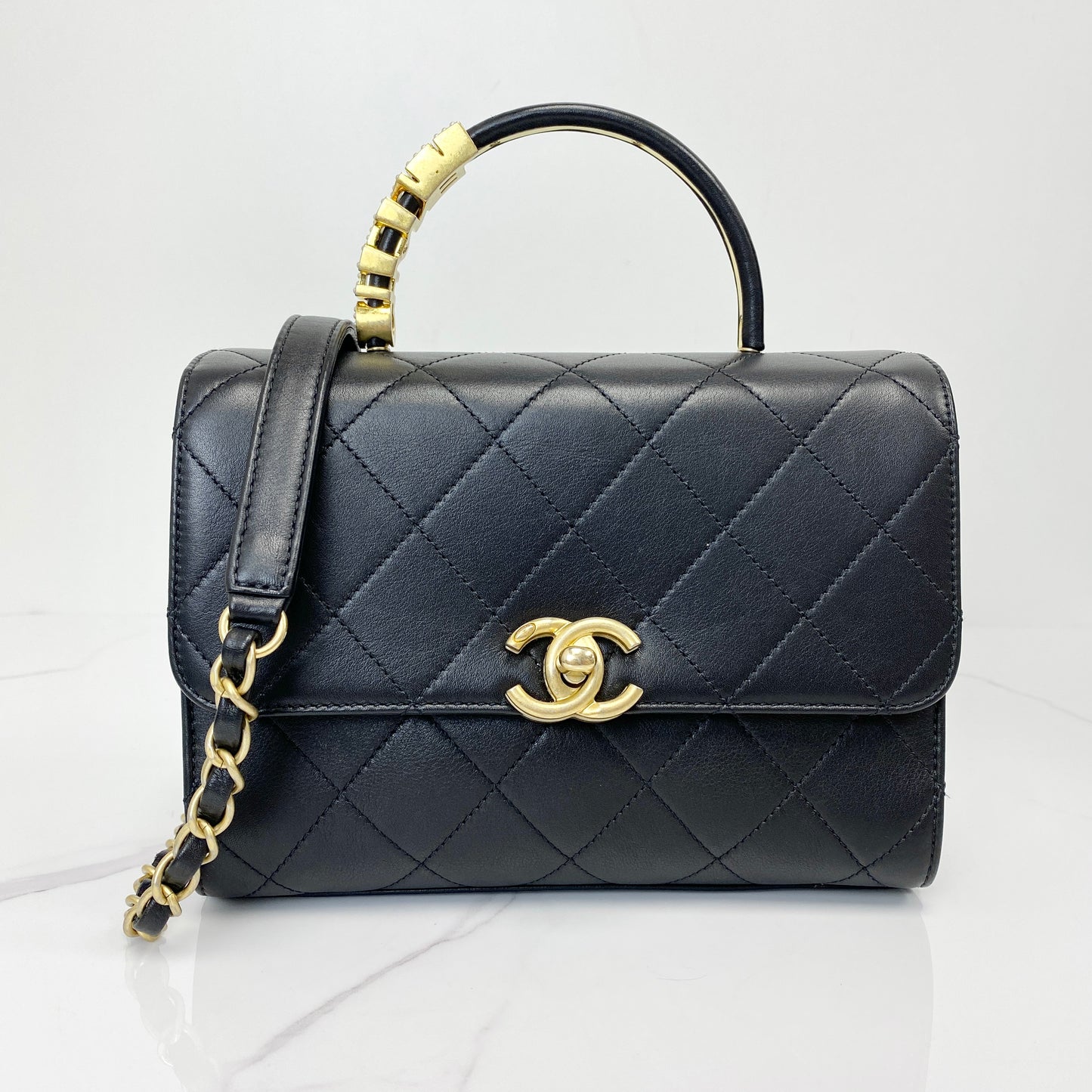 Chanel top handle flap bag in black quilted lambskin with antique gold CC clasp and chain