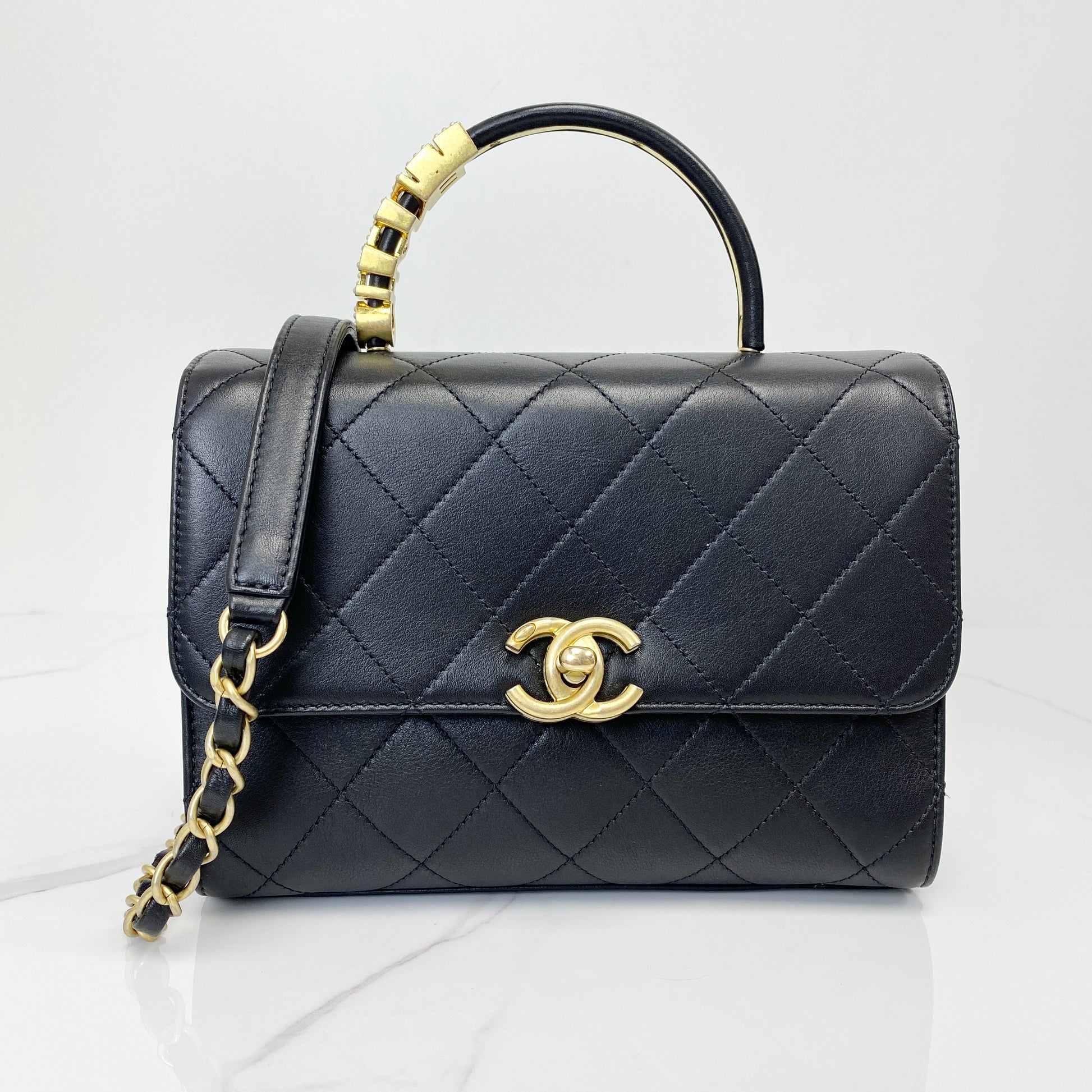 Chanel top handle flap bag in black quilted lambskin with antique gold CC clasp and chain